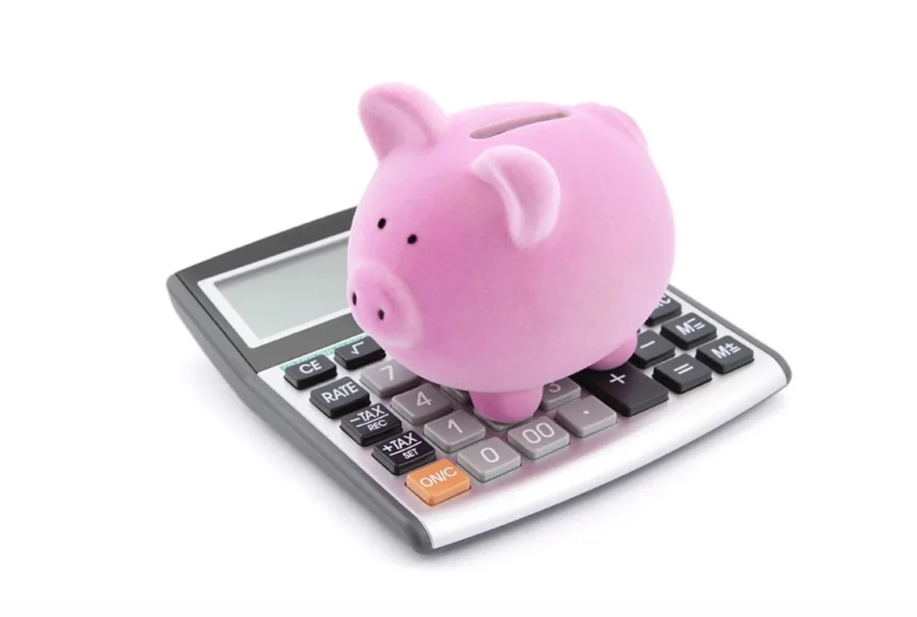 Petit cochon tirelire sur une calculatrice pour réaliser les comptes